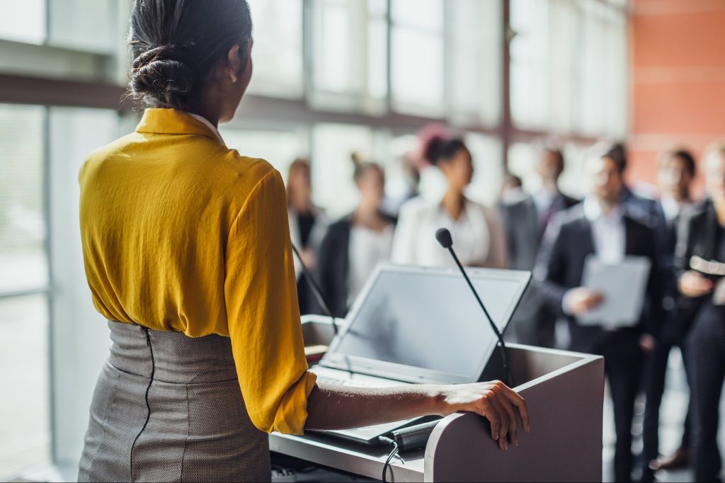 a girl or a woman doing public speech or publicly speaking